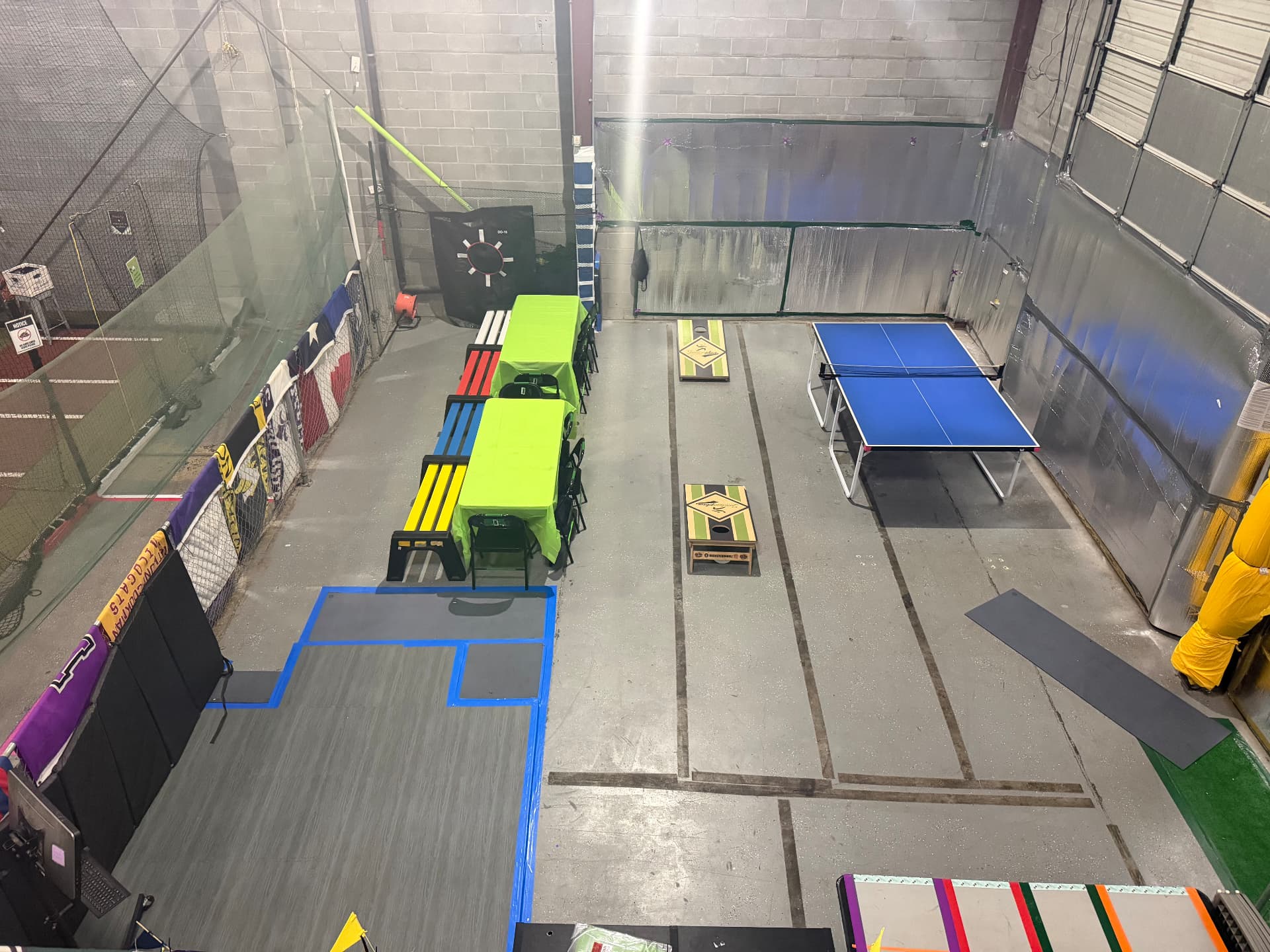The backyard party space at JPLEX from above, with tables, benches, cornhole boards and a ping pong table